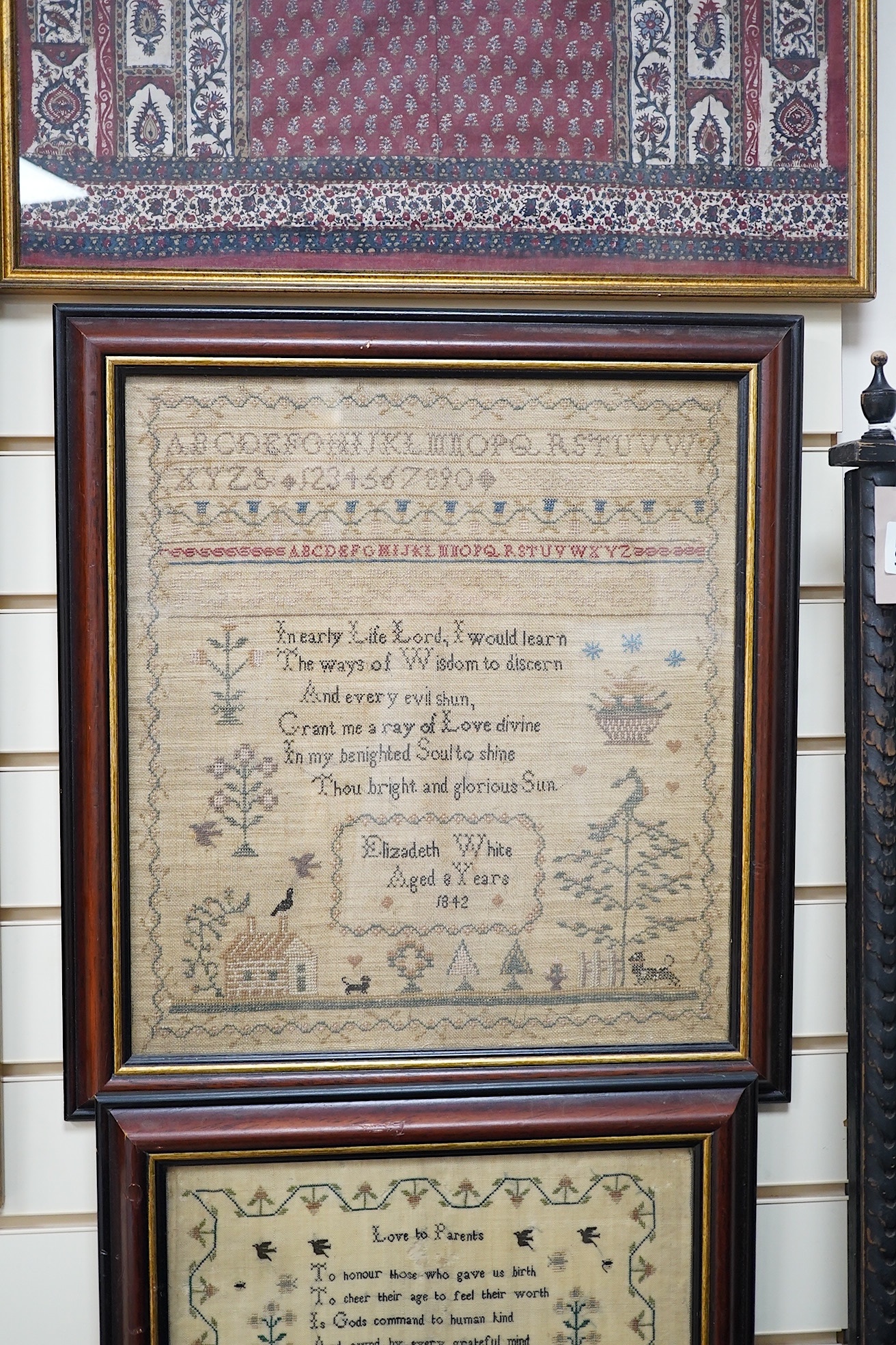 Two mid 19th century samplers worked by Elizabeth White, one dated 1842 aged 8 years, the other 1844 aged 11 years, both worked with a country scene of a house, birds, dogs and trees, the earlier sampler with a top panel